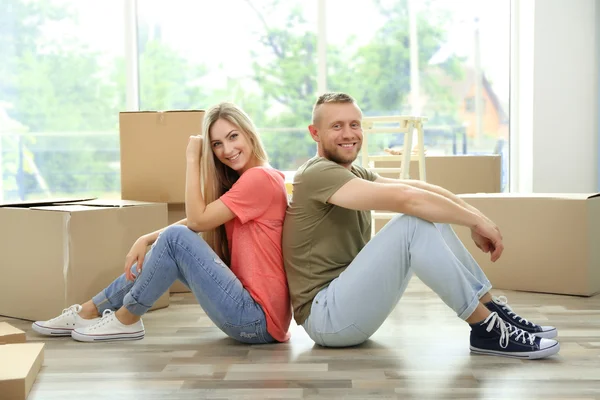 Belo casal sentado no chão de madeira — Fotografia de Stock