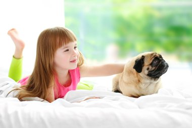 Güzel kız ve yatakta şirin pug