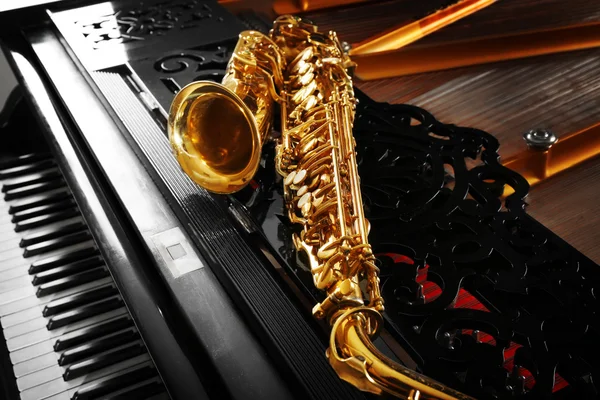 Saxophone lying on the piano — Stock Photo, Image