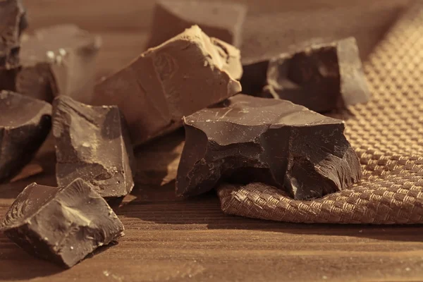 Pezzi di cioccolato sul tavolo di legno — Foto Stock