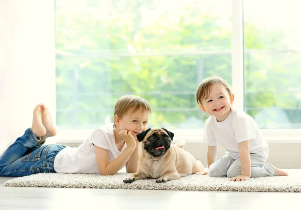 Niedliche Mädchen Und Jungen Mit Mops Auf Dem Fußboden Zimmer — Stockfoto