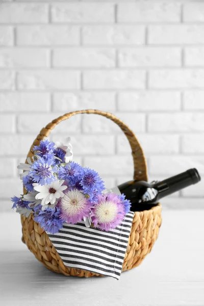 Butelka wina z kwiaty w koszyku — Zdjęcie stockowe