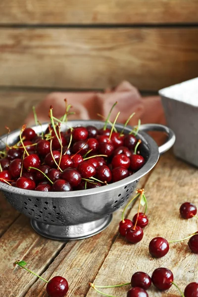 Cerejas em escorredor na mesa — Fotografia de Stock