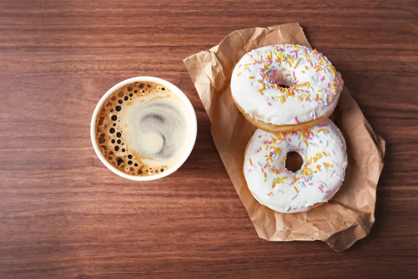 Paper cup of coffee and doughnuts — Stock Photo, Image