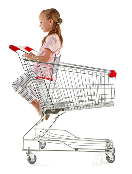 Cute girl sitting in shopping cart — Stock Photo, Image