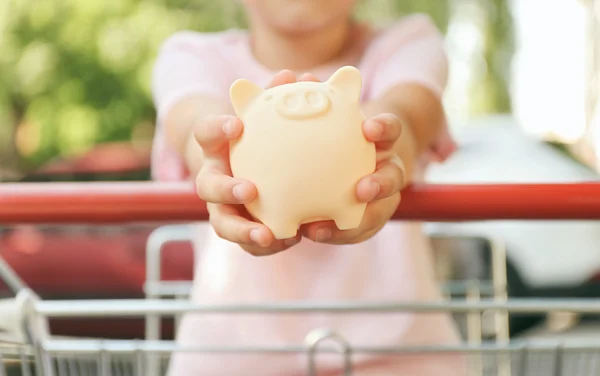 Menina com banco porquinho — Fotografia de Stock