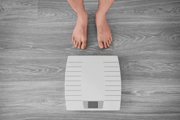 Man standing near weight scales — Stock Photo, Image