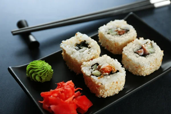 Суши-ролл в черной тарелке — стоковое фото