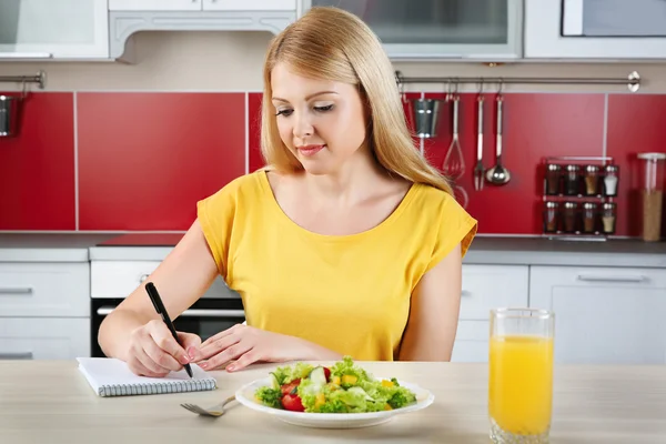 Frau sitzt am Küchentisch — Stockfoto