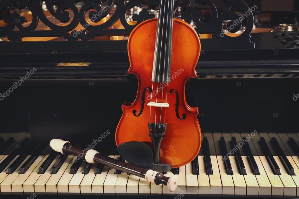 Flute and violin on piano keys — Stock Photo © belchonock 119113942