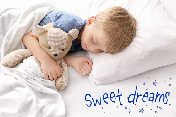 ベッドにテディベアと眠る愛らしい少年 — ストック写真