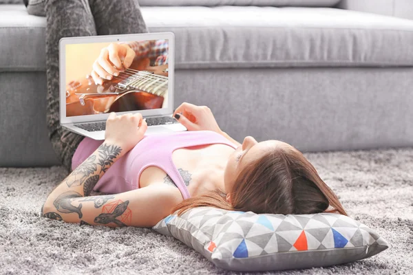 Woman with the laptop lying on the floor