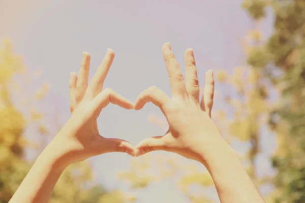 Giovane ragazza che si tiene per mano a forma di cuore — Foto Stock