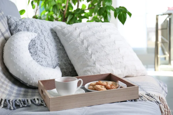 Sofá elegante com chá e biscoitos — Fotografia de Stock