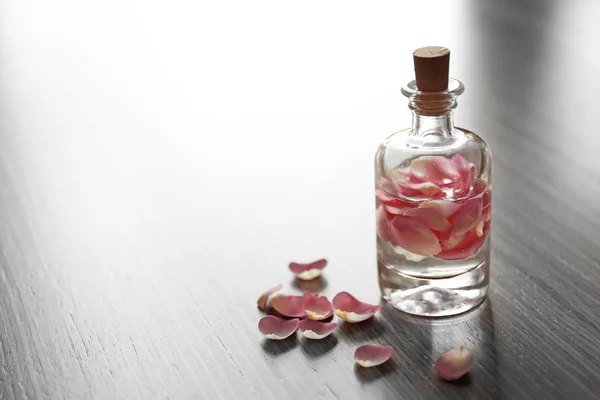 Bouteille avec pétales de rose — Photo