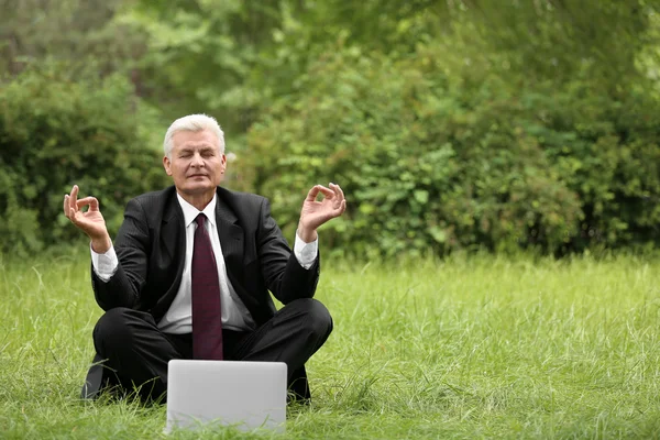 Empresario con laptop relajante en pose de meditación — Foto de Stock