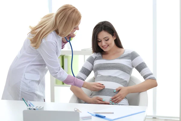 Jonge zwangere vrouw met arts in het ziekenhuis — Stockfoto