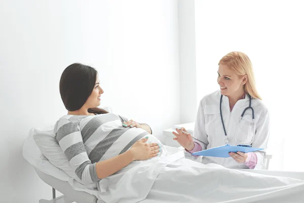 Młoda kobieta w ciąży z lekarzem w szpitalu — Zdjęcie stockowe