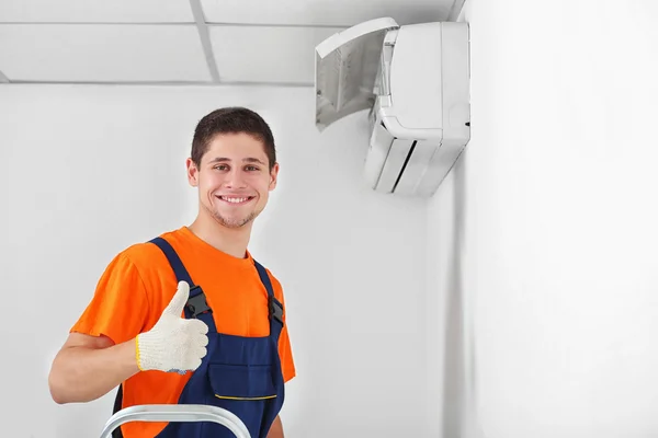 Technicus in de buurt van de airconditioner — Stockfoto