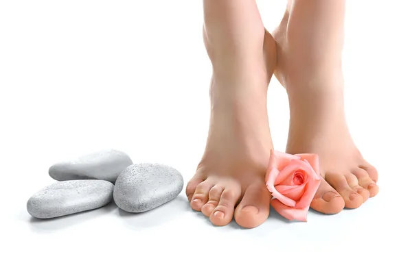 Kvinnliga fötter med spa stenar — Stockfoto
