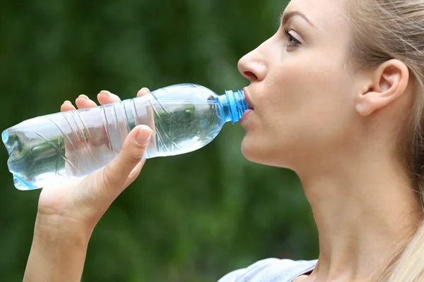 Beautiful girl drinking water on street — Stock Photo, Image