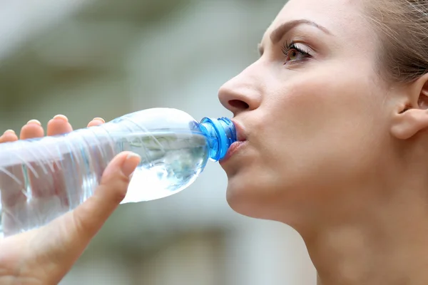 Beautiful girl drinking water on street — Stock Photo, Image