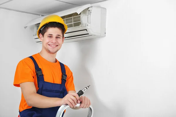 Technician repairing air conditioner Stock Image