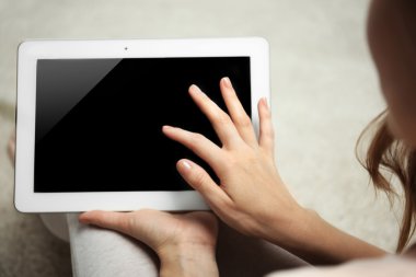 Tablet tutan kadın halı arka plan bulanık