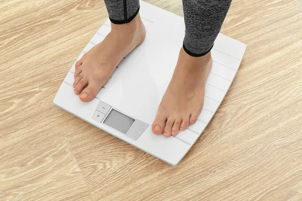 Female bare feet standing on a scales — Stock Photo, Image