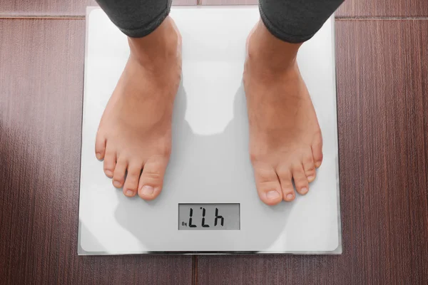 Female bare feet standing on a scales in bathroom — Stock Photo, Image