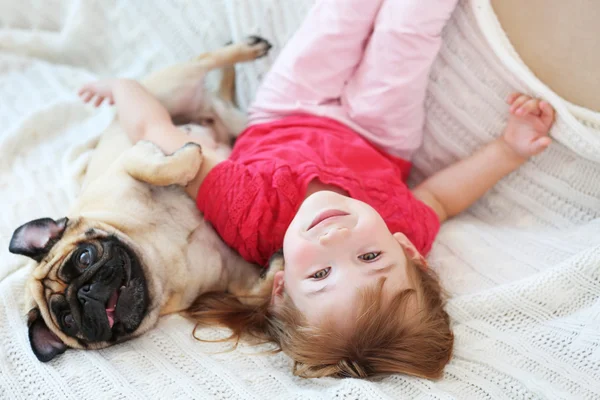 Klein meisje en pug — Stockfoto