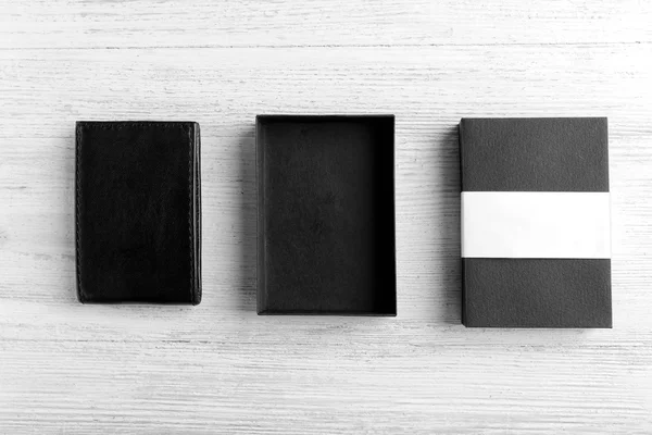 Кожаный бумажник с коробкой на деревянном фоне — стоковое фото