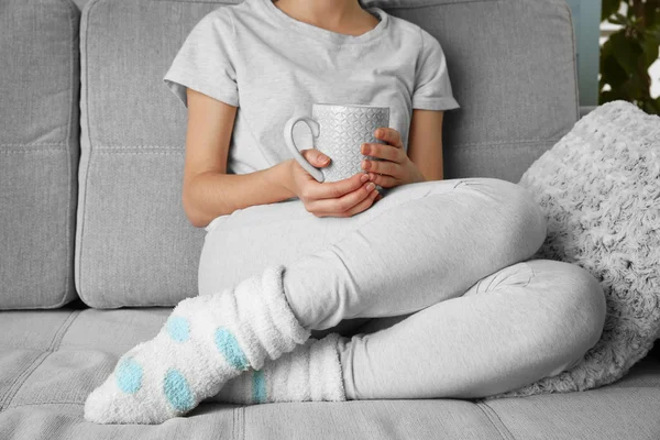 Mulher com xícara de leite no sofá — Fotografia de Stock