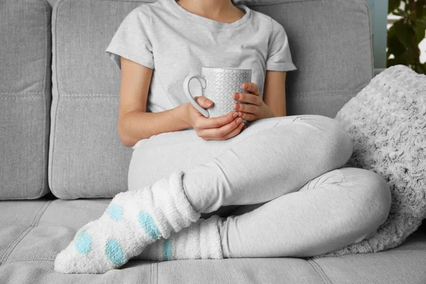 Femme avec tasse de lait sur le canapé — Photo