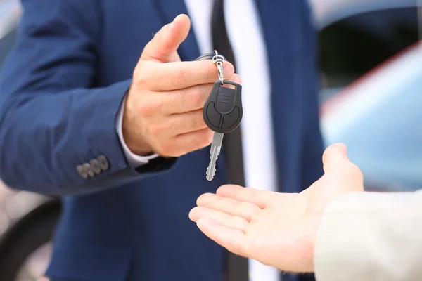 Venditore dando la chiave dell'automobile al primo piano del cliente — Foto Stock