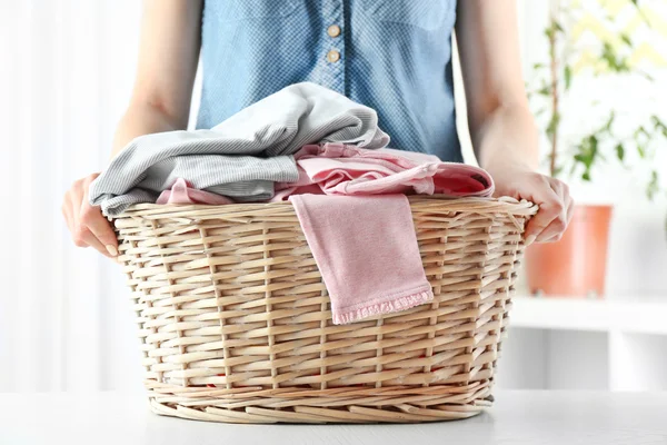 Mujer sosteniendo canasta de mimbre en la lavandería — Foto de Stock