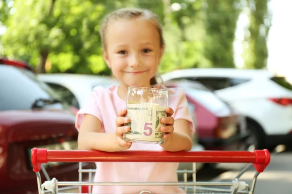 Girl holding bank with money in hands — Stock Photo, Image