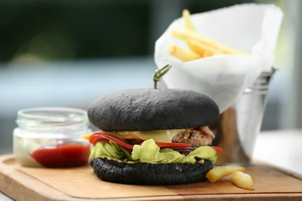 Leckerer schwarzer Burger mit Pommes — Stockfoto