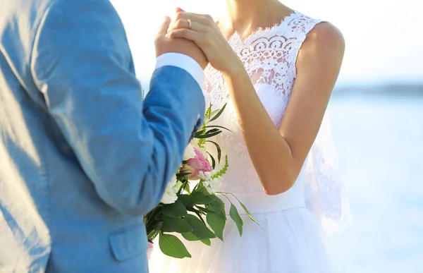 Brudgummen och bruden kramas, utomhus — Stockfoto