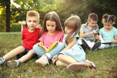 Parkta grup mutlu çocuk okuma kitapları
