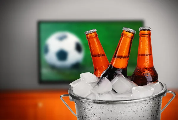 Beer in front of football — Stock Photo, Image