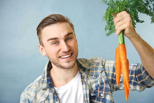 Hombre guapo con zanahorias — Foto de Stock