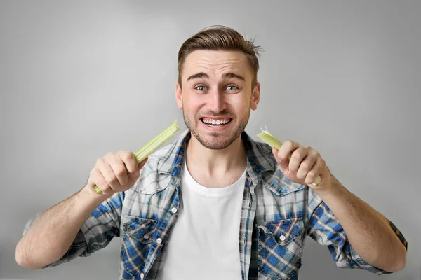 Hombre guapo comiendo apio — Foto de Stock