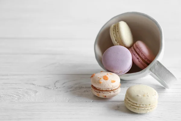 Tasty macaroons and white cup — Stock Photo, Image