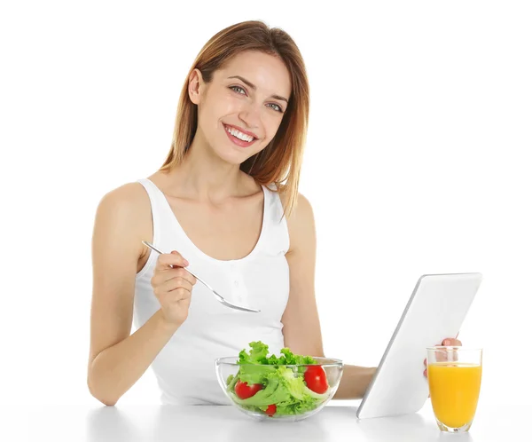 Mujer con tableta comiendo alimentos saludables —  Fotos de Stock