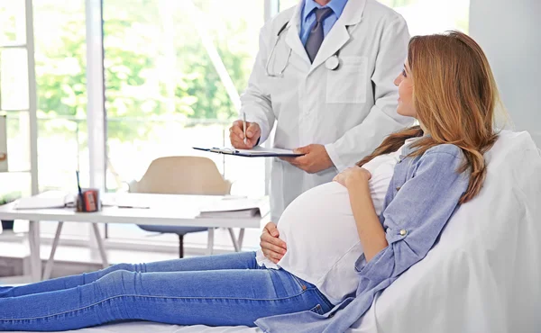 Mujer joven embarazada que visita al médico — Foto de Stock