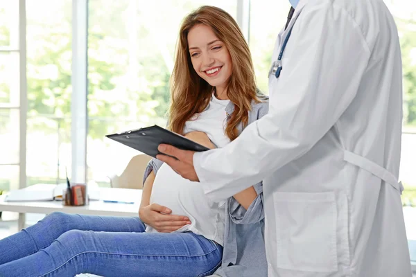 Mujer joven embarazada que visita al médico — Foto de Stock