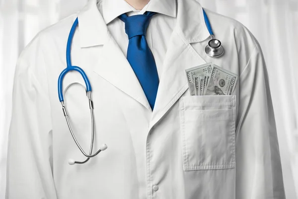 Arzt mit Geld im Mantel — Stockfoto