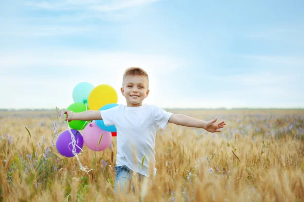 Pequeño niño feliz con globos — Foto de Stock