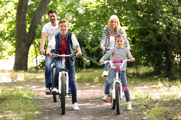 Happy family on bike ride in park